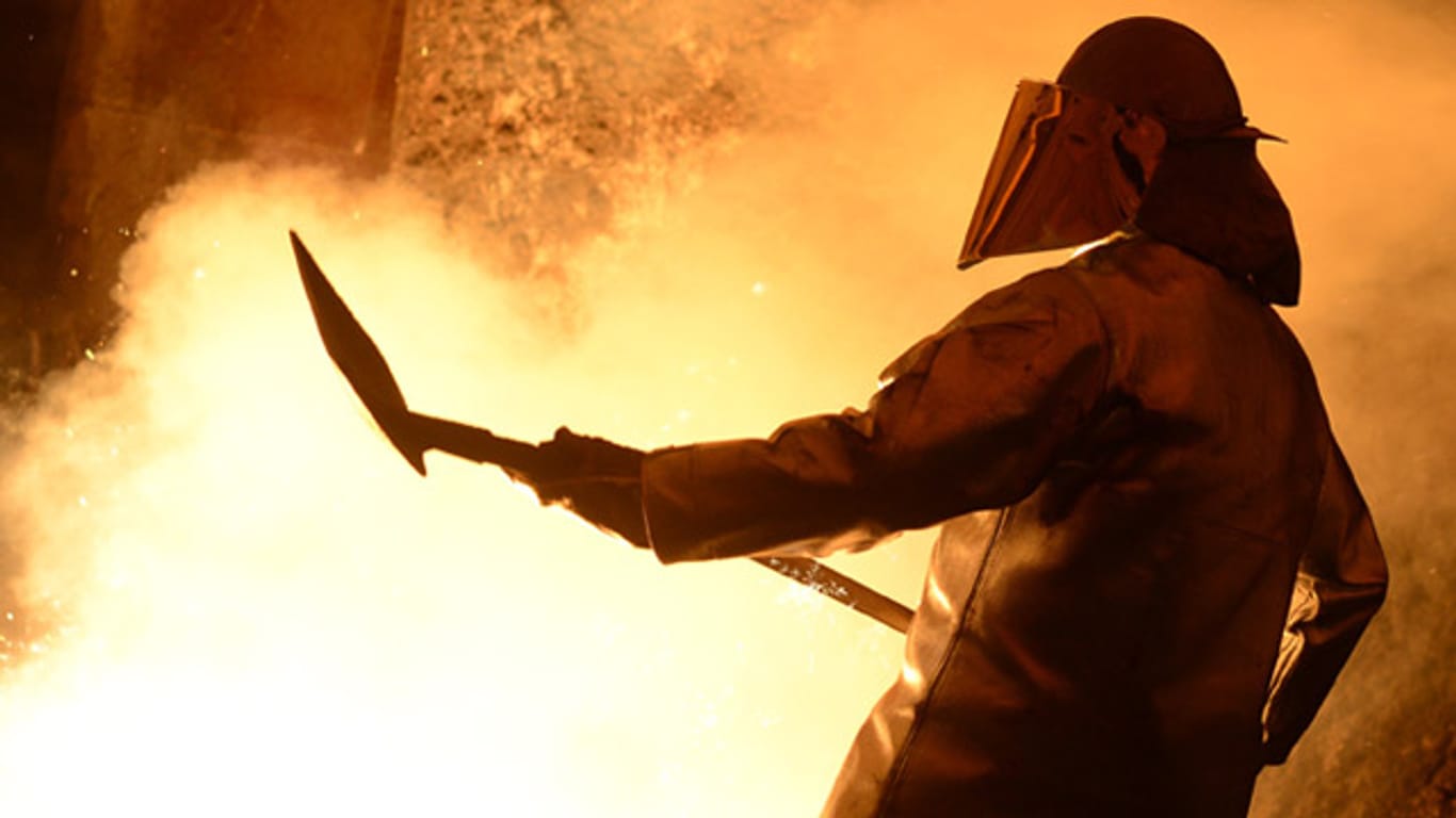 Ein Stahlwerker der Salzgitter AG schaufelt Sand in den glühenden Stahl. Die Branchenkrise bedroht Tausende Jobs in dem Stahlkonzern