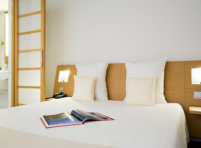 Die Einrichtung der Gästezimmer folgt einer klaren Linie, helle Holzmöbel wurden mit Bettwäsche in den Farben Weiß und Beige kombiniert. Ab 90 Euro pro Person und Nacht.