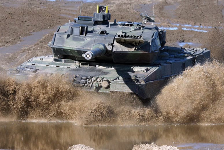 Ein Kampfpanzer vom Typ Leopard 2 bei der Fahrt durch ein Flussbett