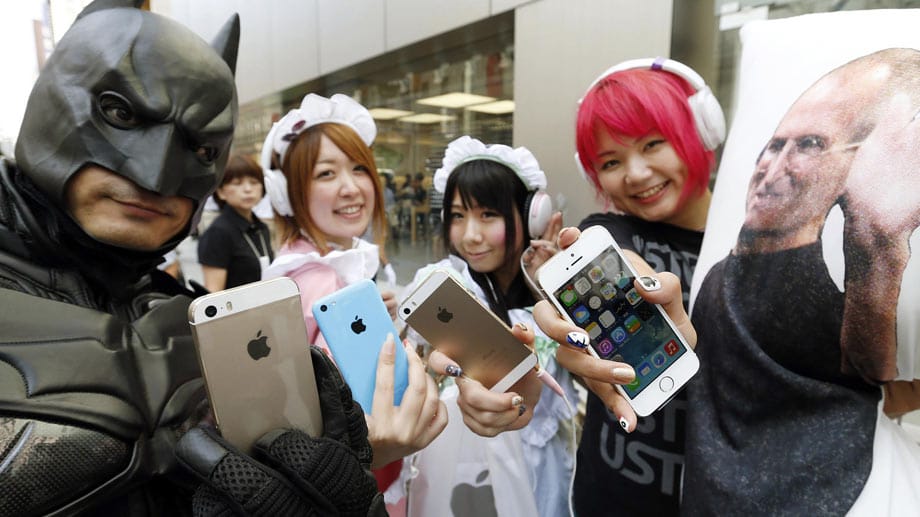 Maskierte Japaner halten iPhone 5s und iPhone 5c in die Kamera