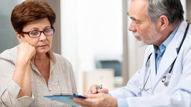 Frau beim Arzt (Symbolbild): Wägen Sie beim Wechsel der Krankenkasse die Vor- und Nachteile ab.