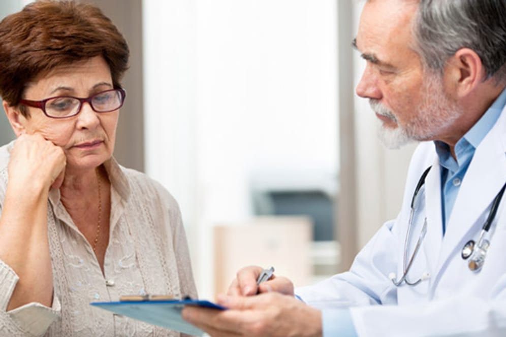 Frau beim Arzt (Symbolbild): Wägen Sie beim Wechsel der Krankenkasse die Vor- und Nachteile ab.