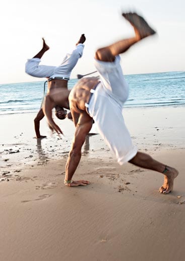 Das akrobatische Zusammenspiel von Angriff und Abwehr zeigen Capoeira-Tänzer in Salvador de Bahia.
