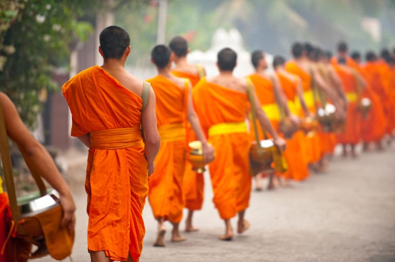 Safranfarbene Roben wohin man sieht: Buddhistische Mönche prägen das Bild der laotischen Stadt Luang Prabang, wo der Buddhismus tief im Alltag verwurzelt ist.