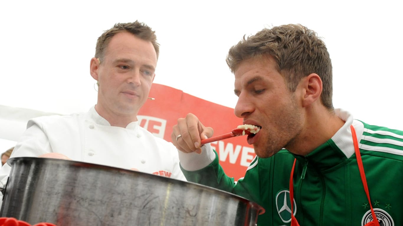 Thomas Müller (re.) lässt sich im Teamhotel bei der EM 2012 das Essen von Sternekoch Holger Stromberg schmecken.