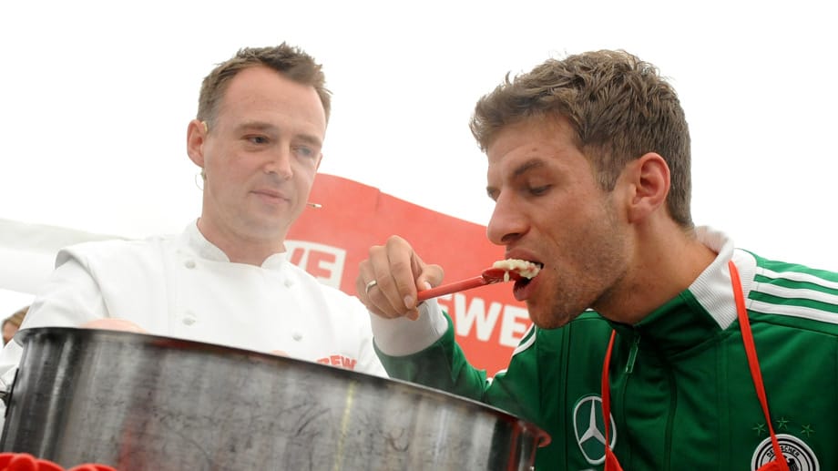 Thomas Müller (re.) lässt sich im Teamhotel bei der EM 2012 das Essen von Sternekoch Holger Stromberg schmecken.