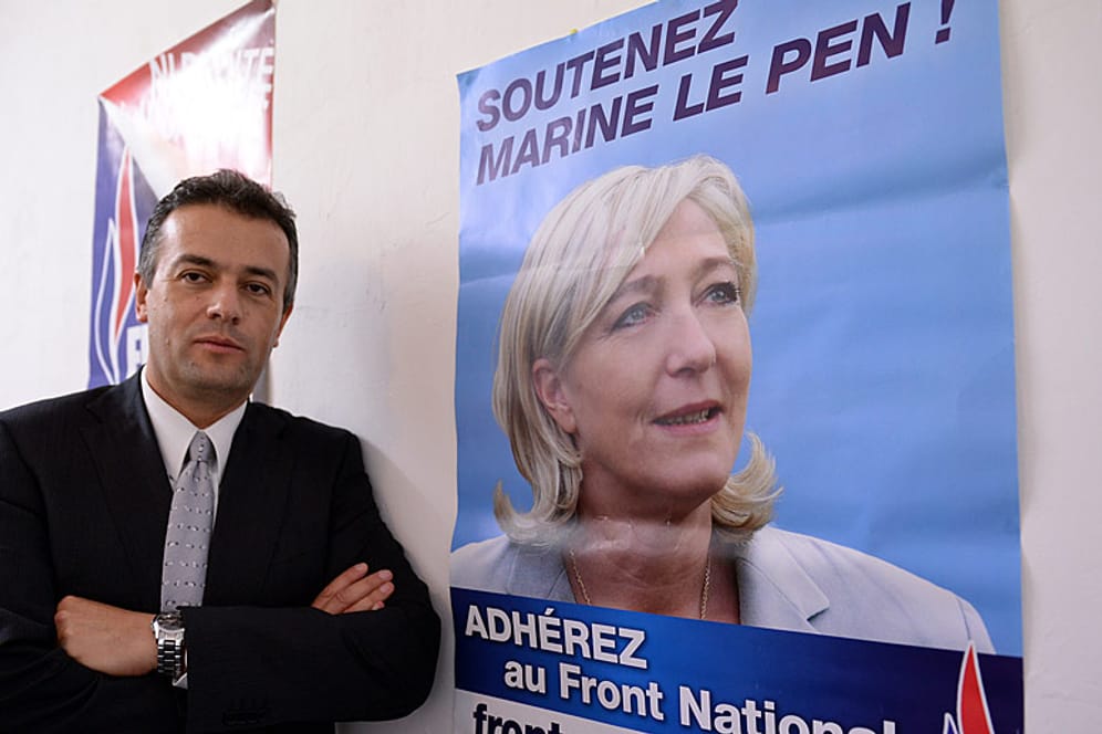 Laurent Lopez posiert neben einem Plakat der FN-Vorsitzenden Marine Le Pen.