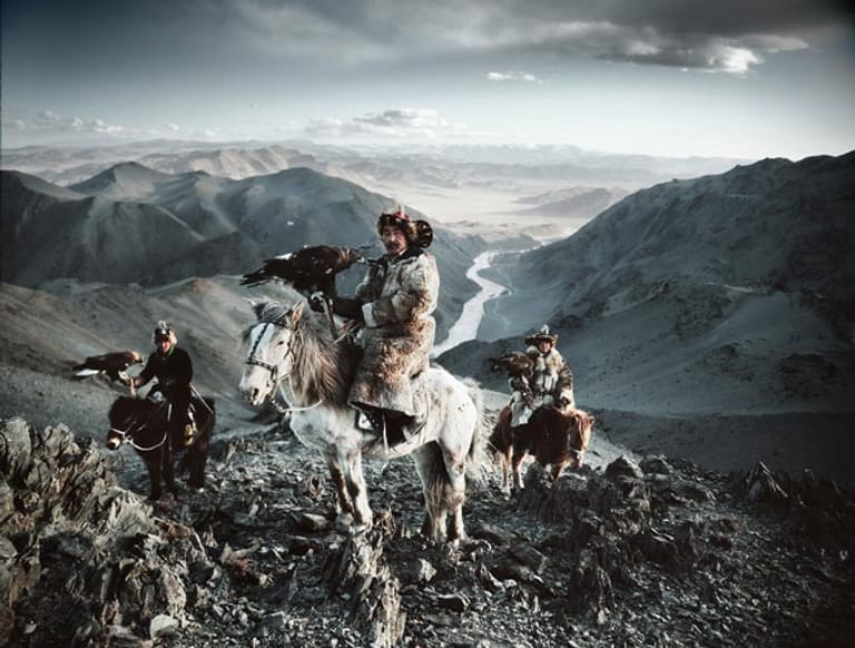 Drei kasachische Jäger mit ihren Greifvögeln, Provinz Bajan-Ölgii, Mongolei.