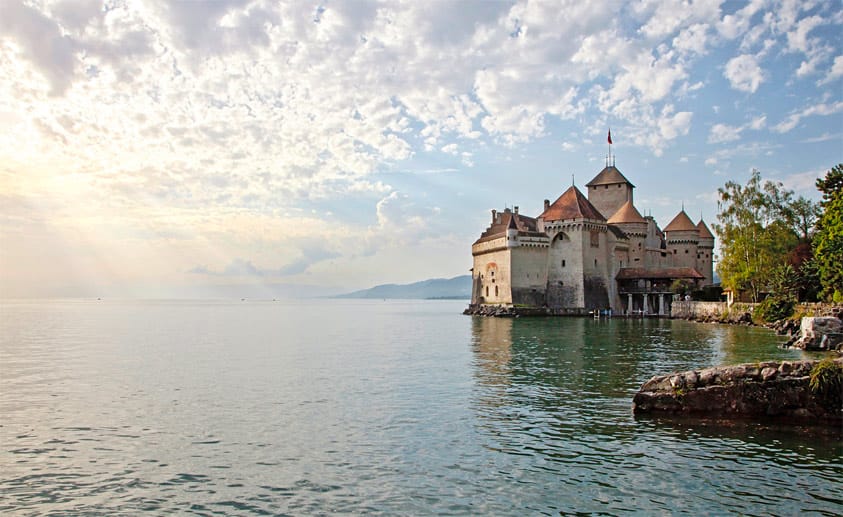 Vom Festland getrennt durch einen zehn Meter breiten Graben liegt die Wasserburg Chillon in Veytaux, fünf Kilometer südöstlich von Montreux, im Genfer See.