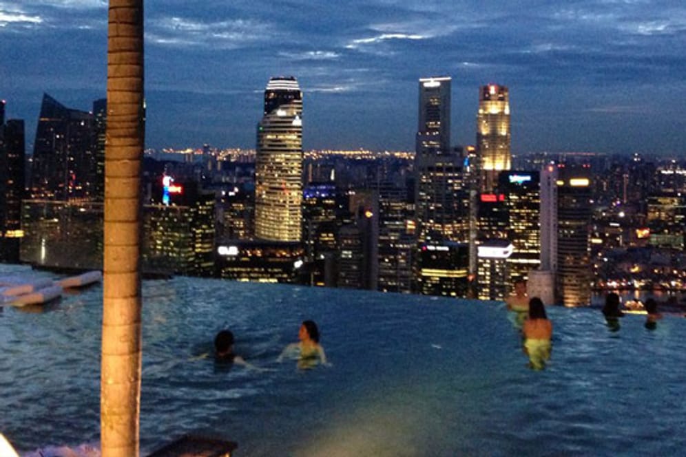 Im Infinity-Pool des "Marina Bay Sands“ in Singapur scheint die glänzende Silhouette der Stadt zum Greifen nah.