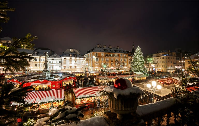 Stimmungsvoll geht es auf den Weihnachtsmärkten in Südtirol zu: Auf dem Waltherplatz in Bozen erstrahlen die Marktstände traditionell im Kerzenschein.