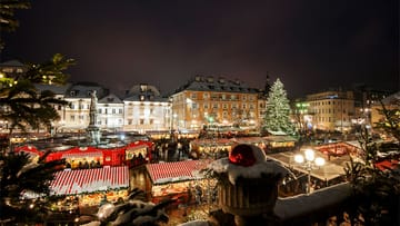 Stimmungsvoll geht es auf den Weihnachtsmärkten in Südtirol zu: Auf dem Waltherplatz in Bozen erstrahlen die Marktstände traditionell im Kerzenschein.