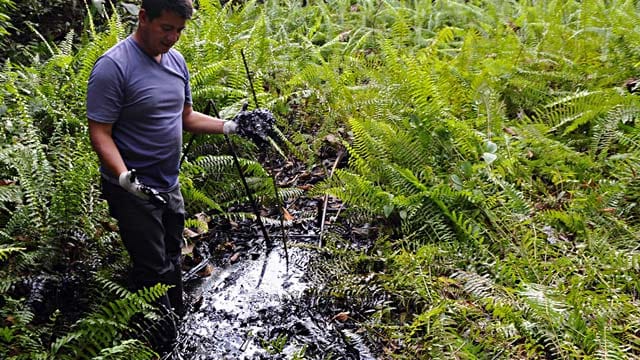 Ein Aktivist aus Ecuador zeigt die Umweltverschmutzung durch Chevron im Amazonas