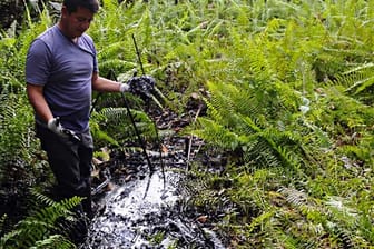 Ein Aktivist aus Ecuador zeigt die Umweltverschmutzung durch Chevron im Amazonas