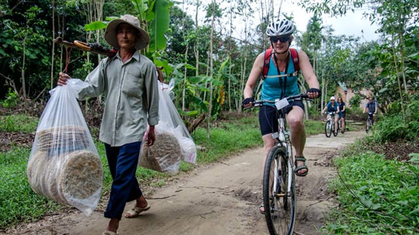 Radfahren neben Reisbrotträger in Vietnam.