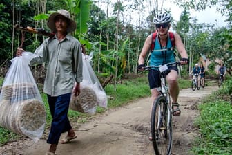 Radfahren neben Reisbrotträger in Vietnam.