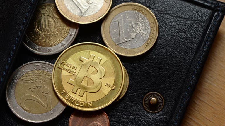 Eine Bitcoin-Münze zwischen Euro-Münzen.