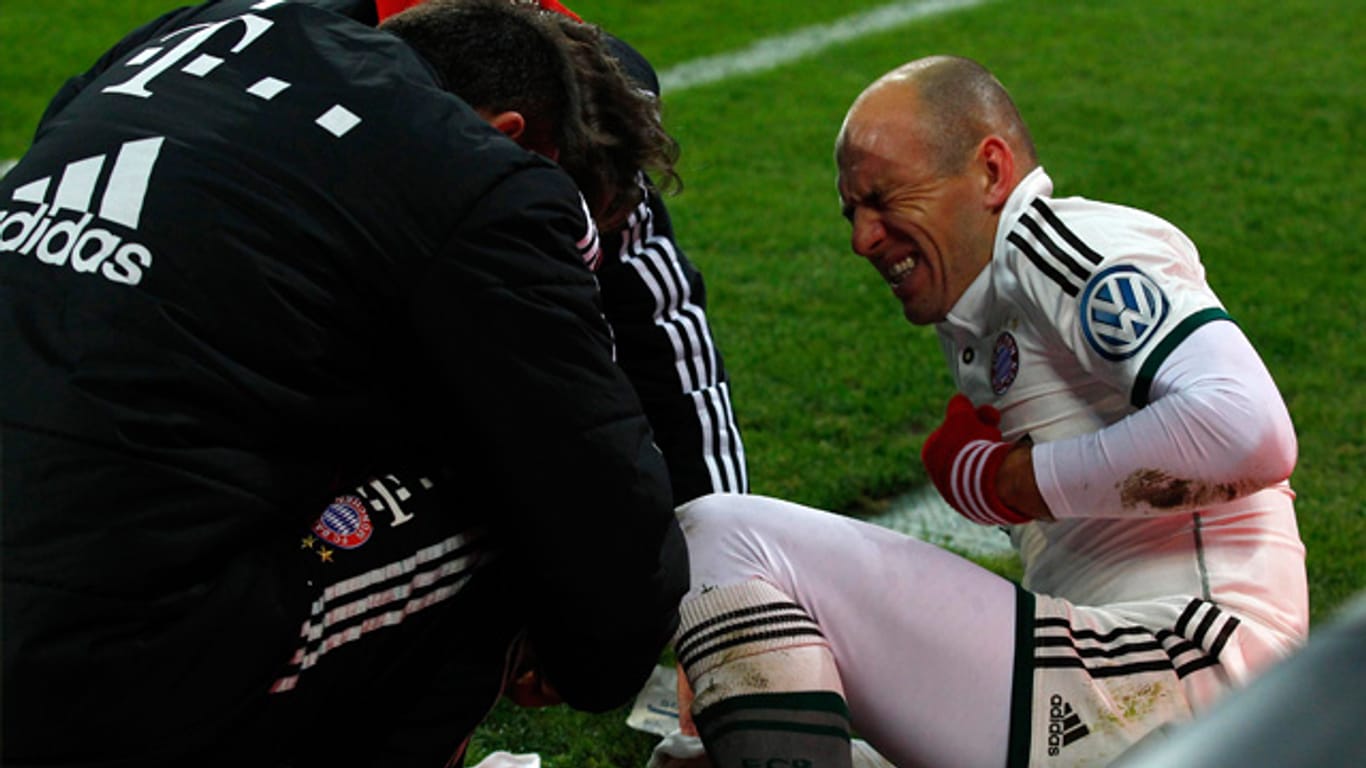 Arjen Robben wird von der medizinischen Abteilung des FC Bayern nach dem Zusammenstoß mit Marvin Hitz versorgt.
