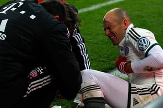 Arjen Robben wird von der medizinischen Abteilung des FC Bayern nach dem Zusammenstoß mit Marvin Hitz versorgt.