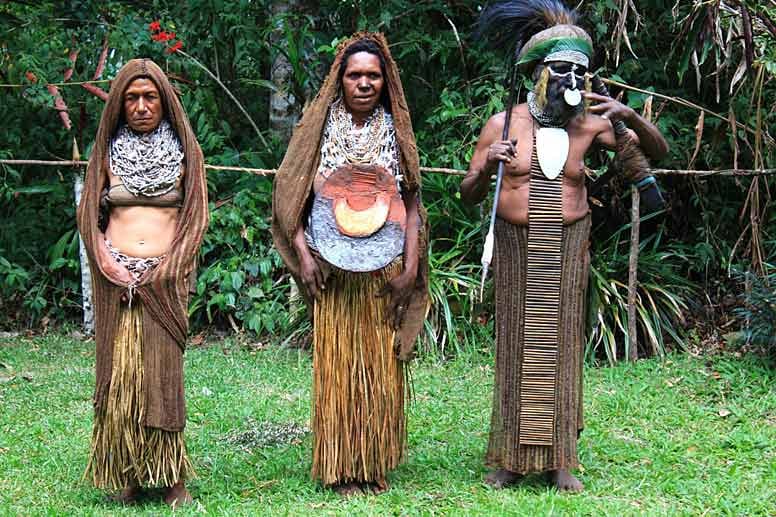 Dorfältester im Hochland von Papua Neuguinea mit zwei seiner Frauen.
