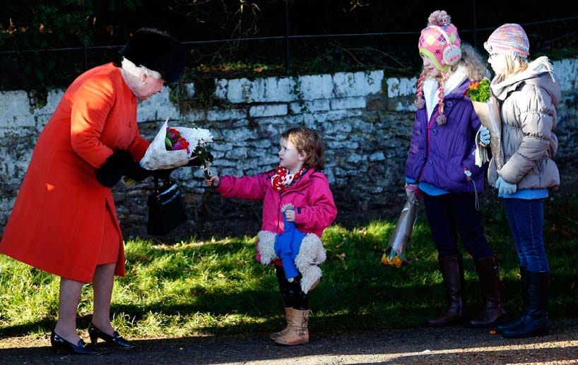 Die Queen (li.) bekommt von vielen Kindern zu Weihnachten Blumen überreicht.