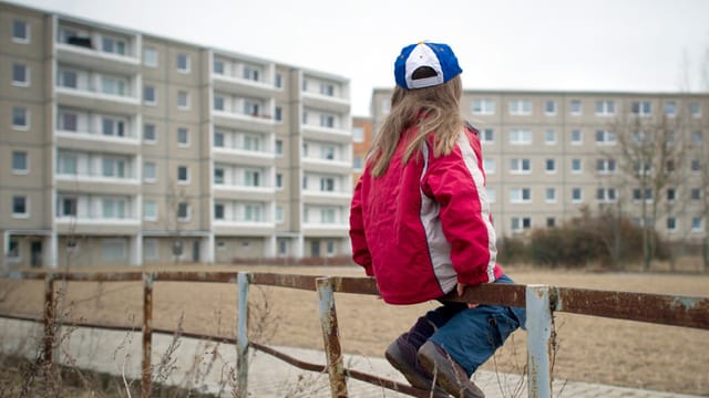 Ein Kind sitzt auf einem Geländer (Symbolbild): Armut trifft vor allem unter 18-Jährige in Bremen.