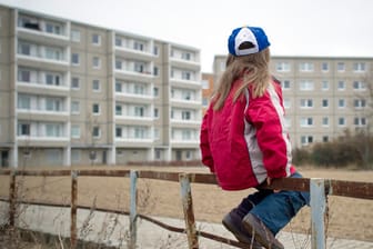 Ein Kind sitzt auf einem Geländer (Symbolbild): Armut trifft vor allem unter 18-Jährige in Bremen.