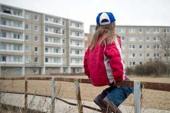Ein Kind sitzt auf einem Geländer (Symbolbild): Armut trifft vor allem unter 18-Jährige in Bremen.