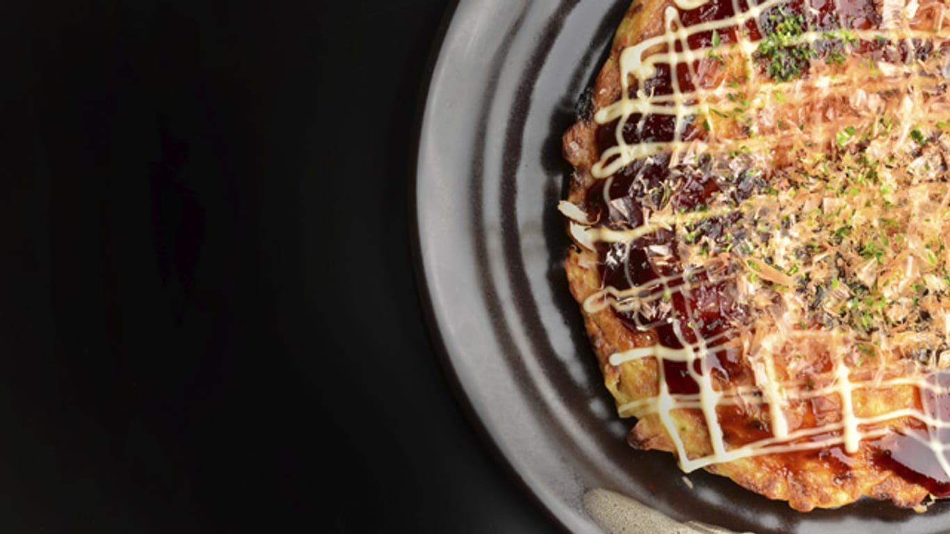 Eine Pizza mal ganz anders: Okonomiyaki wird in einer Pfanne zubereitet und besteht hauptsächlich aus Wasser, Mehl und Ei.