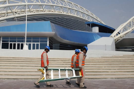 Erschöpfte Arbeiter laufen im Januar 2013 am Aspire Dome in Katar vorbei.