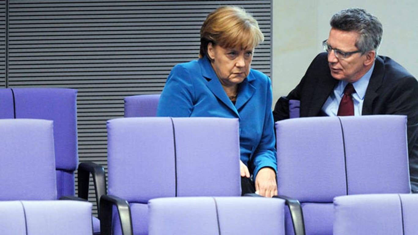 Im Visier von Menschenrechtsgruppen: Bundeskanzlerin Angela Merkel und Innenminister Thomas de Maizière