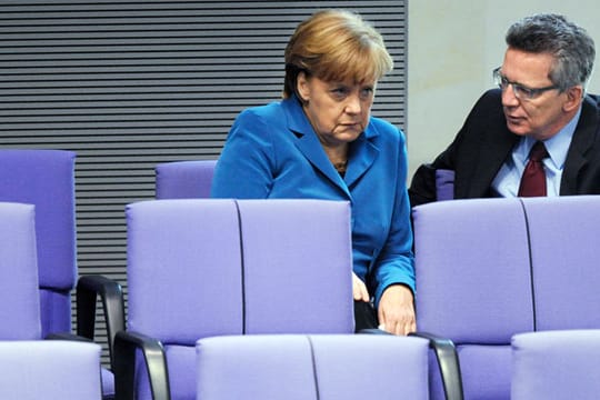 Im Visier von Menschenrechtsgruppen: Bundeskanzlerin Angela Merkel und Innenminister Thomas de Maizière