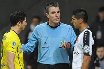 Referee Knut Kircher ermahnt Carlos Zambrano (re.) und Robert Lewandowski.