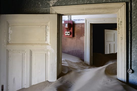 In Kolmanskop dringt Sand durch Türen und Fenster, die Wüste holt sich die Stadt zurück.