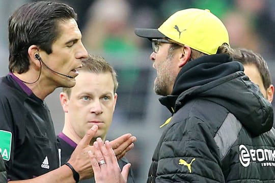 Schiedsrichter Deniz Aytekin (li.) versucht, BVB-Coach Jürgen Klopp zu beruhigen.
