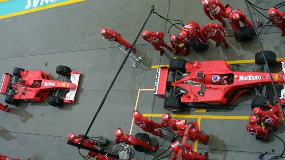 Michael Schumacher (li.) muss sich beim Boxenstopp hinten anstellen.