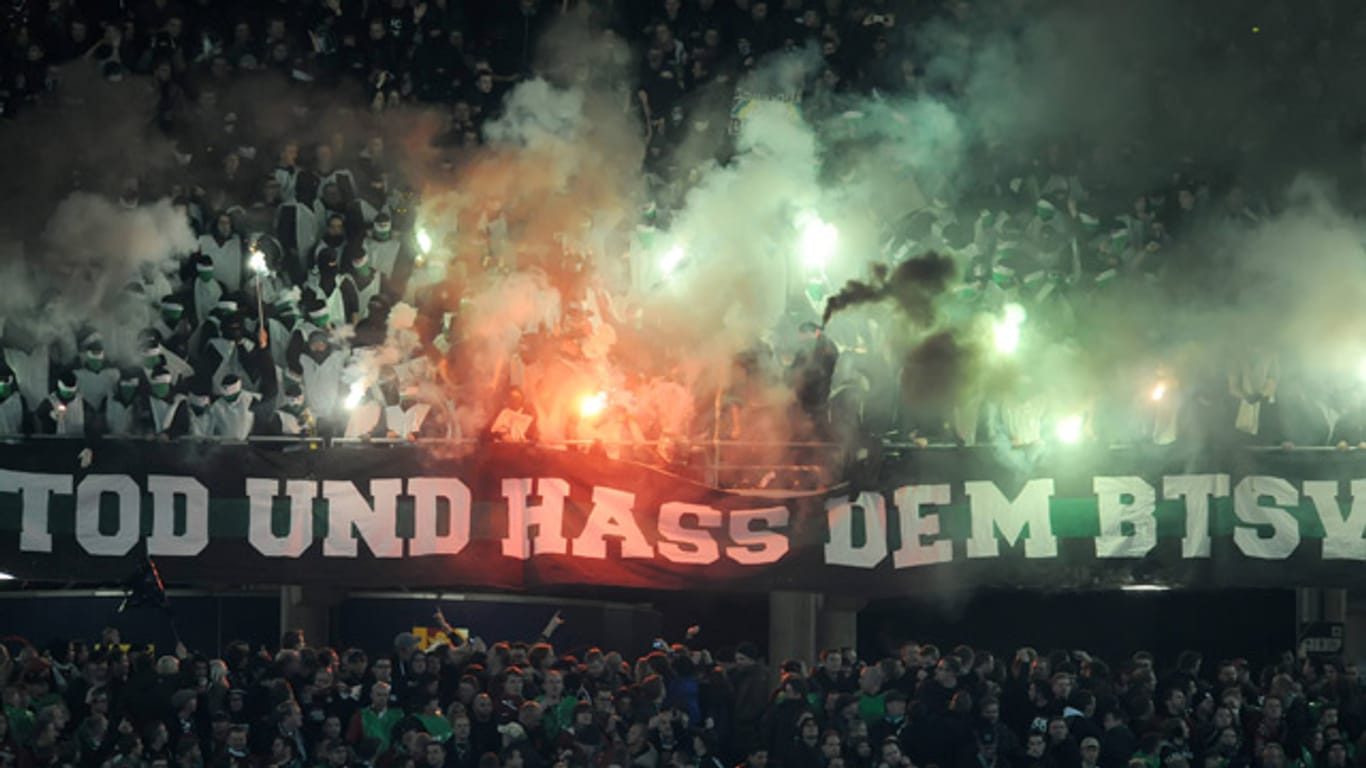 Anhänger von Hannover 96 zünden im November 2013 beim Bundesliga-Duell gegen Eintracht Braunschweig Pyrotechnik.