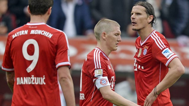 Mario Mandzukic (l.), Bastian Schweinsteiger (Mitte) und Daniel von Buyten sind restlos bedient: In Augsburg geht eine Serie von 53 Bundesligaspielen ohne Niederlage zu Ende.