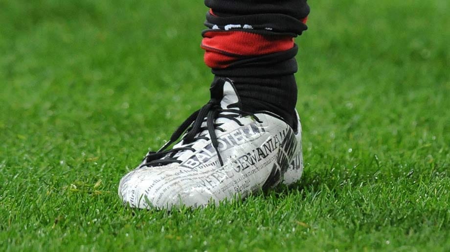 Die Schuhe des Stürmers vom AC Mailand sind rund um mit Ausschnitten von Zeitungsartikel bedeckt. Nicht bunt aber definitiv anders.
