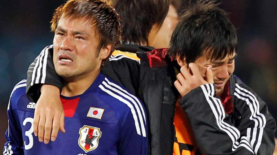 Die sonst so zurückhaltenden Japaner können ihr Ausscheiden kaum fassen. Nur knapp verlieren sie 2010 im Achtelfinale das Elfmeterschießen gegen Paraguay. Anschließend muss ein Betreuer der japanischen Herren (re.) beim Versuch, Yuichi Komano zu trösten, selbst anfangen zu weinen.
