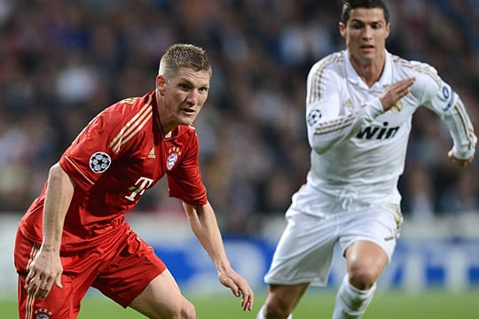 Bayern Münchens Bastian Schweinsteiger (li.) enteilt Real Madrids Cristiano Ronaldo.