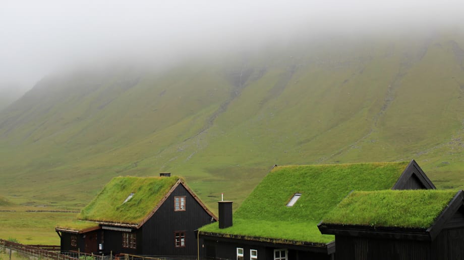 Steile Berge umzingeln Gásadalur - nicht selten verschwinden deren Kämme in dichten Nebel- und Wolkenschwaden.