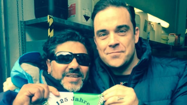 "Die Hand Gottes trifft Gott" - Robbie Williams mit dem falschen Maradona. "Die Hand Gottes trifft Gott" - Robbie Williams mit dem falschen Maradona.