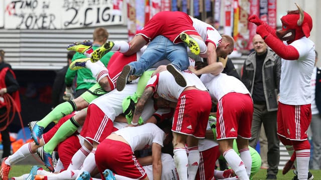 Spieler und Maskottchen jubeln: RB Leipzig marschiert im Profifußball weiter nach oben.