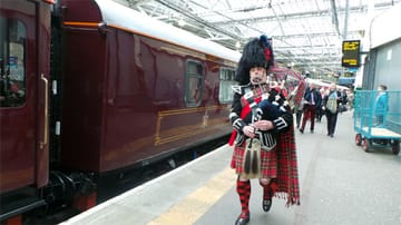 Auf dem Bahnhof weist der Dudelsack-Spieler den Weg zum Royal Scotsman