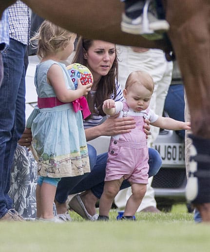Prinz George sah in seiner rot-weiß gestreiften Latzhose bezaubernd aus. Mama Kate half dem kleinen Thronfolger, der seine ersten Gehversuche am Spielfeldrand eines Polospiels wagte.