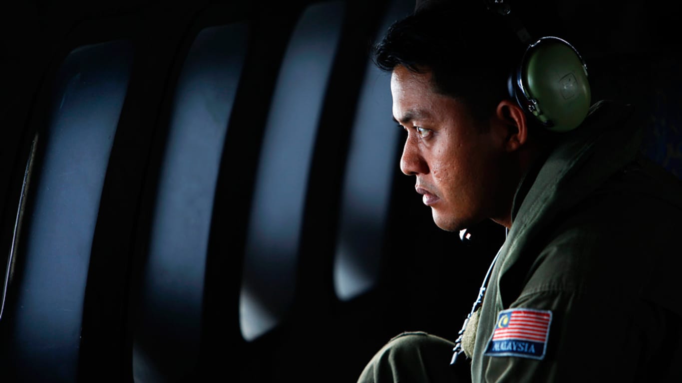 Ein Mitglied der Royal Malaysian Air Force schaut auf der Suche nach dem vermissten Flug MH370 durch ein Flugzeug-Fenster.