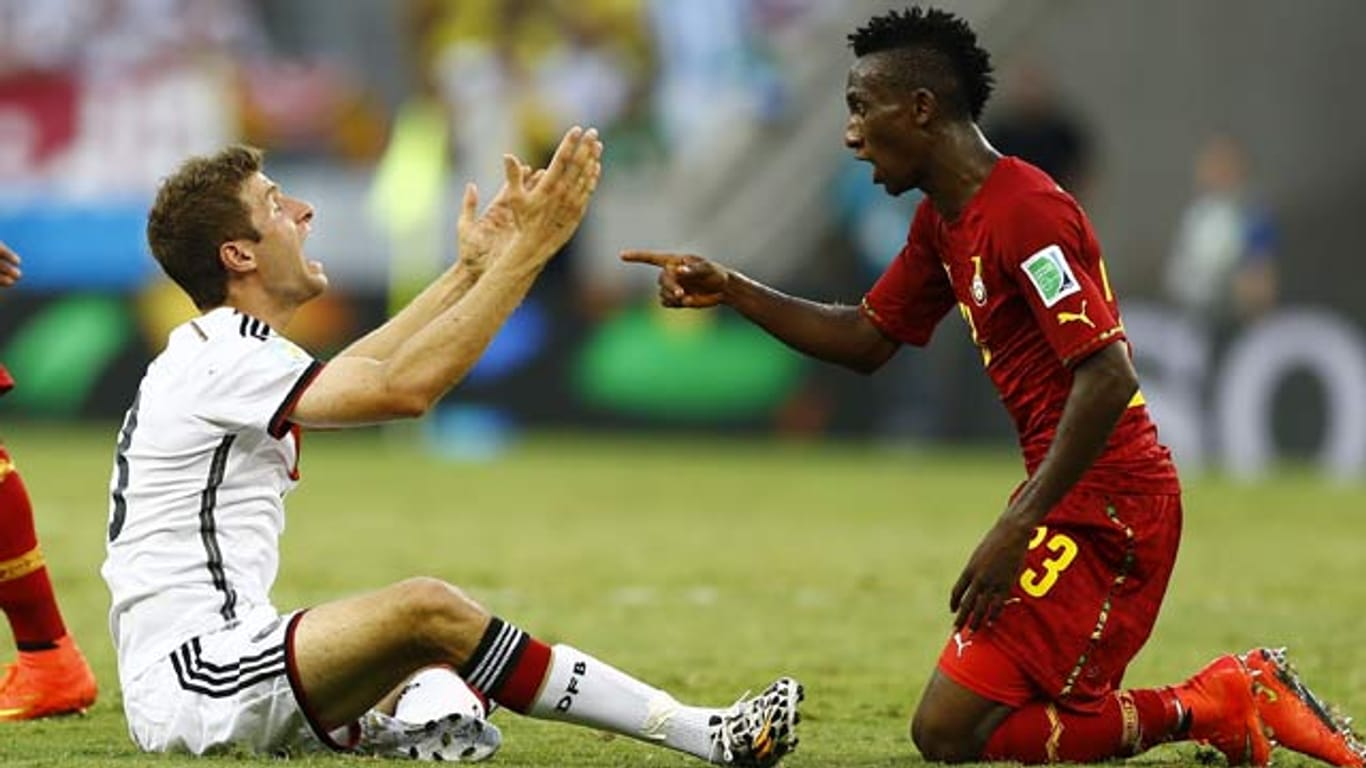 Thomas Müller (li.) und Ghanas Harrison Afful geraten nach einem Zweikampf aneinander.