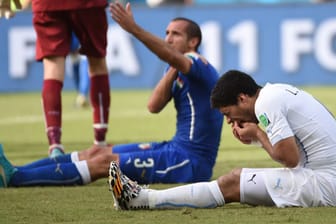 Luis Suarez (vorne) hält sich nach seiner Attacke gegen Giorgio Chiellini die Zähne.