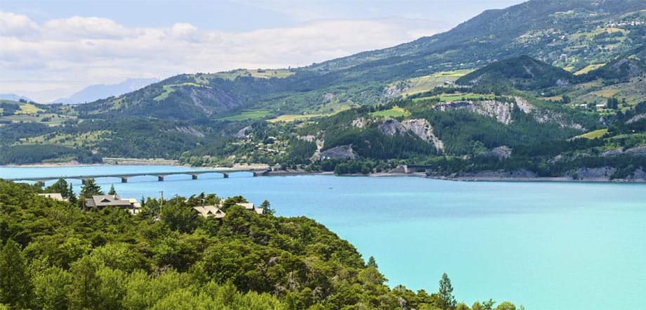 Mitten in der unbändigen Natur der französischen Alpen im Department Hautes-Alpes liegt der Lac de Serre-Ponçon. Der tiefblaue Stausee ist 20 Kilometer lang. Eingebettet zwischen mächtige, mehr als 2000 Meter hohe Berge, bietet der See die idealen Voraussetzungen zum Baden in wildromantischer Umgebung - und für jede Form von Wassersport.
